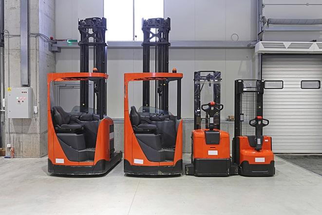 forklift operator lifting pallet in a distribution center